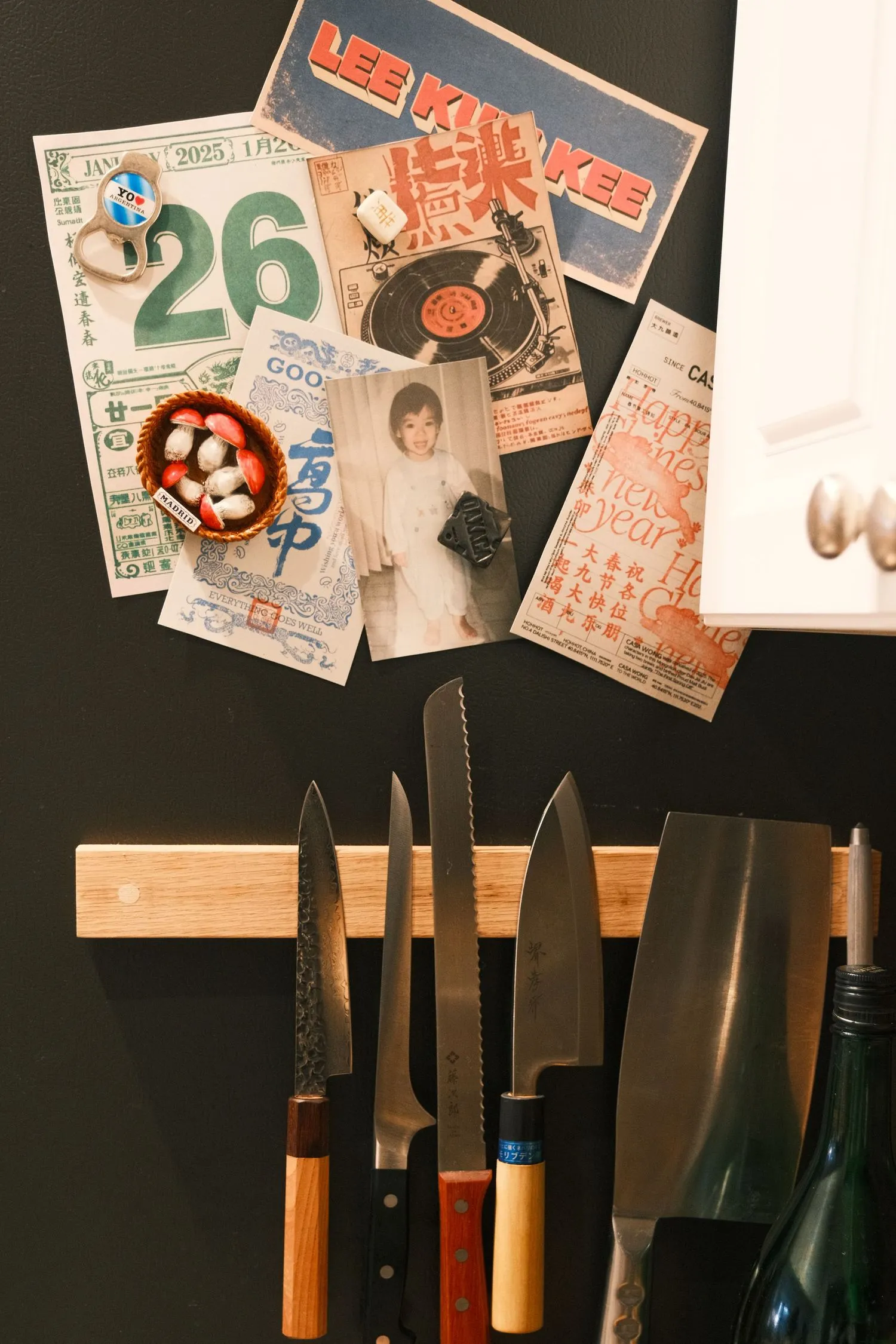 Kitchen set design wall with Chinese ephemera, posters, and knives