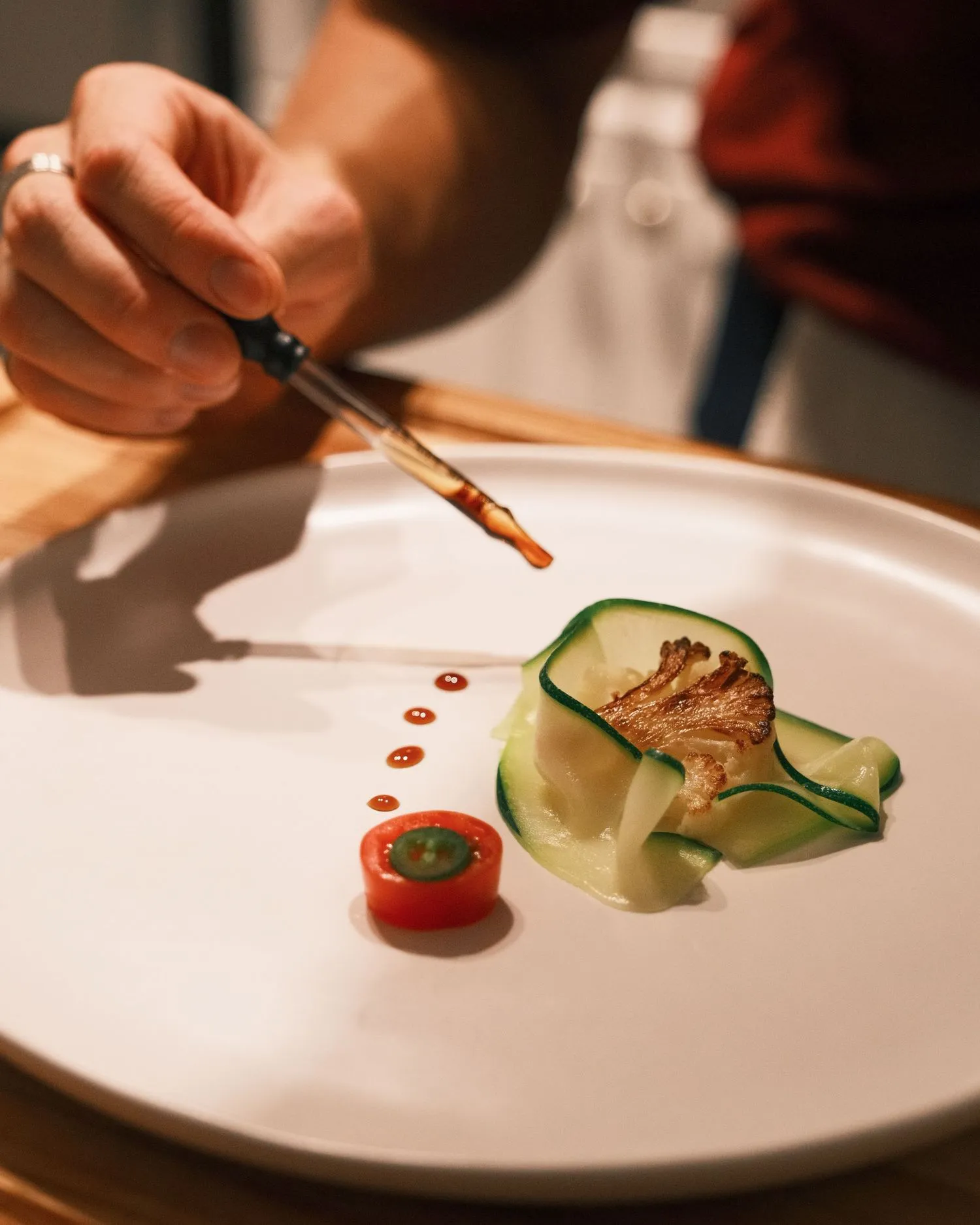Sauce brushed onto a plate during the plating scene